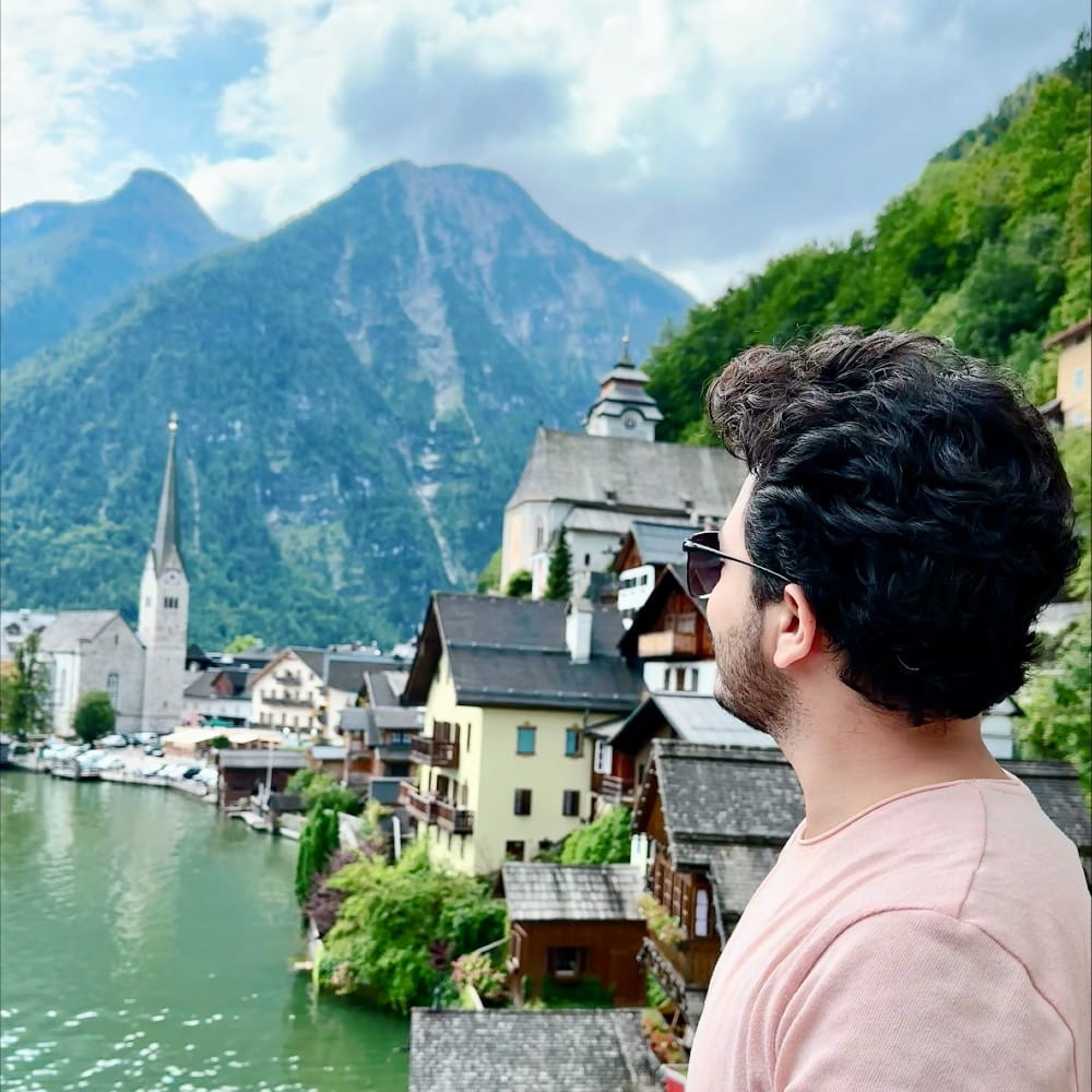 Kushal, a student looks out over a view in Germany of a mountain and a lake