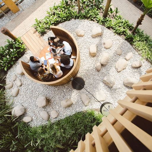 Birds eye view of a group of people working at a circular study pod in the business building