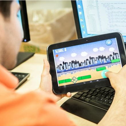 A student analysing a video game on a small tablet device