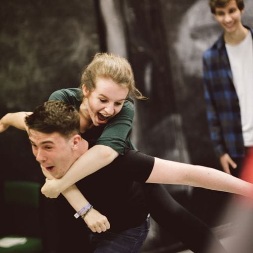 Student giving another student a piggyback in a drama studio