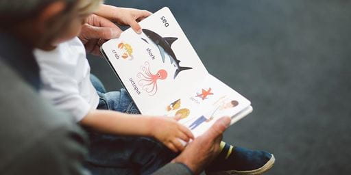 an adult and a child with a children's picture book