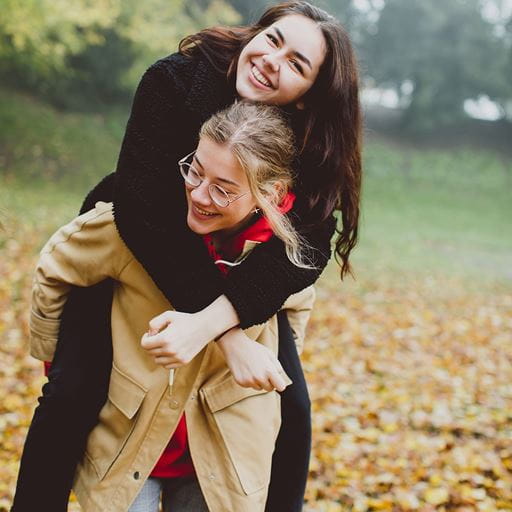 Two smiling girls outside
