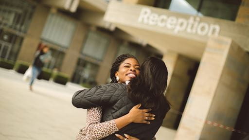 student and parent hugging