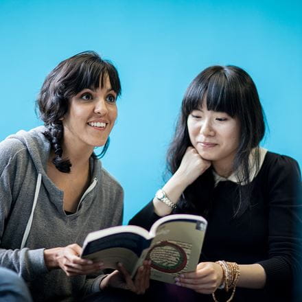 Two girls reading a book
