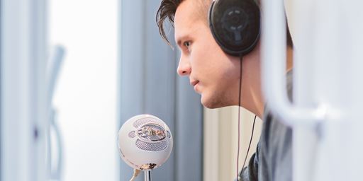 man wearing headphones speaking into microphone