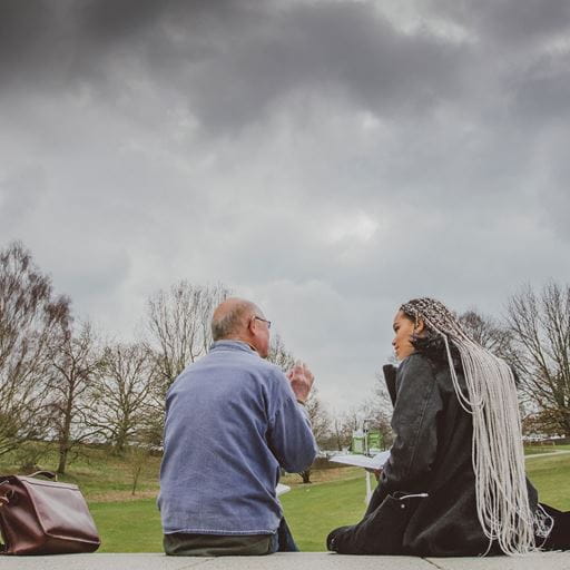 A student and teaching talking with a stormy sky above