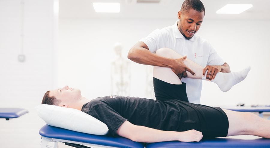 Physiotherapy student practising techniques with another student