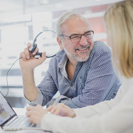Two researchers talking over a laptop