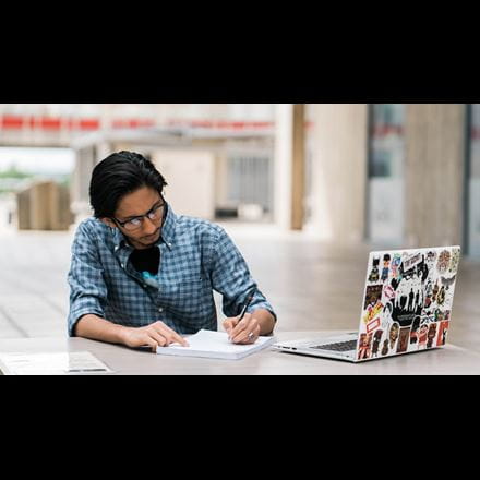 A student downloading the University of Essex postgraduate prospectus on their laptop.