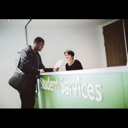 Student enquiring at student services desk