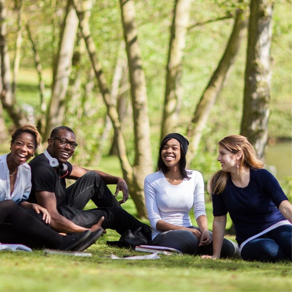 A group of students laughing together by the lakes